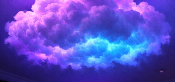 Cloud-shaped LED ceiling light glowing in purple and blue in a room
